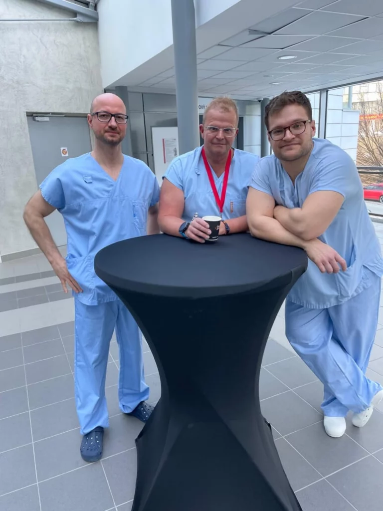 MUDr. Igor Dolan, Ph.D., který operaci komentoval přihlížejícím v přednáškovém sále, spolu s operujícím chirurgem prim. MUDr. Petrem Filipenským, Ph.D., a asistujícím chirurgem MUDr. Filipem Gistlem.